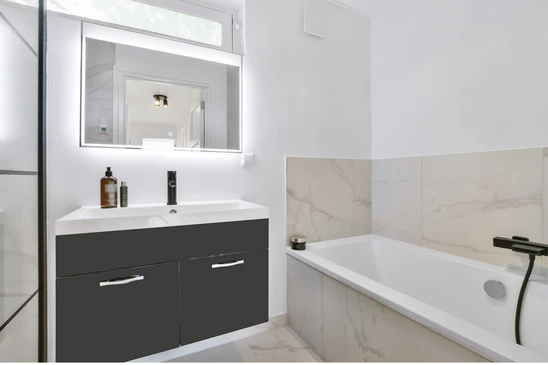 Salle de bain moderne avec baignoire encastr&eacute;e, meuble vasque suspendu anthracite &agrave; deux tiroirs, miroir LED rectangulaire
