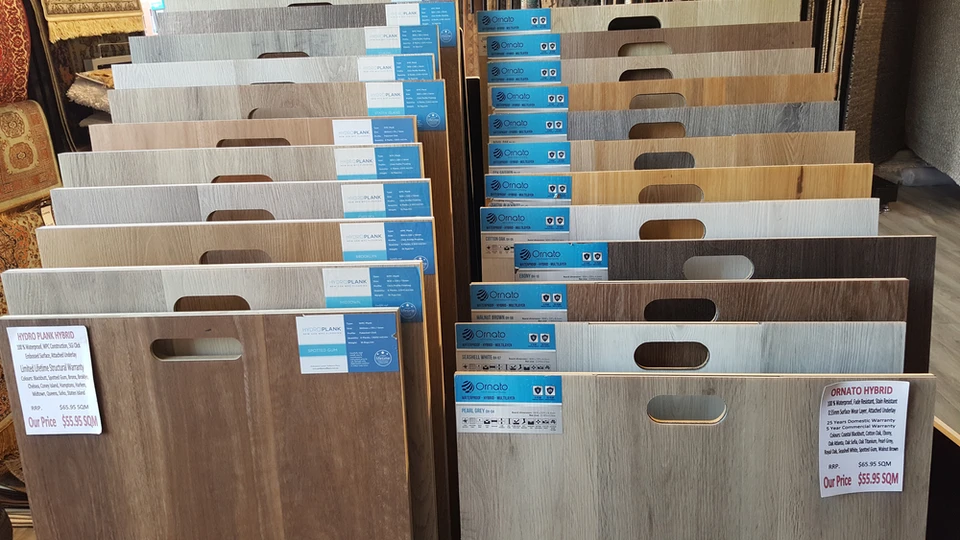 Intérieur d'un magasin de revêtements de sol avec présentoir organisé d'échantillons de parquet et stratifié