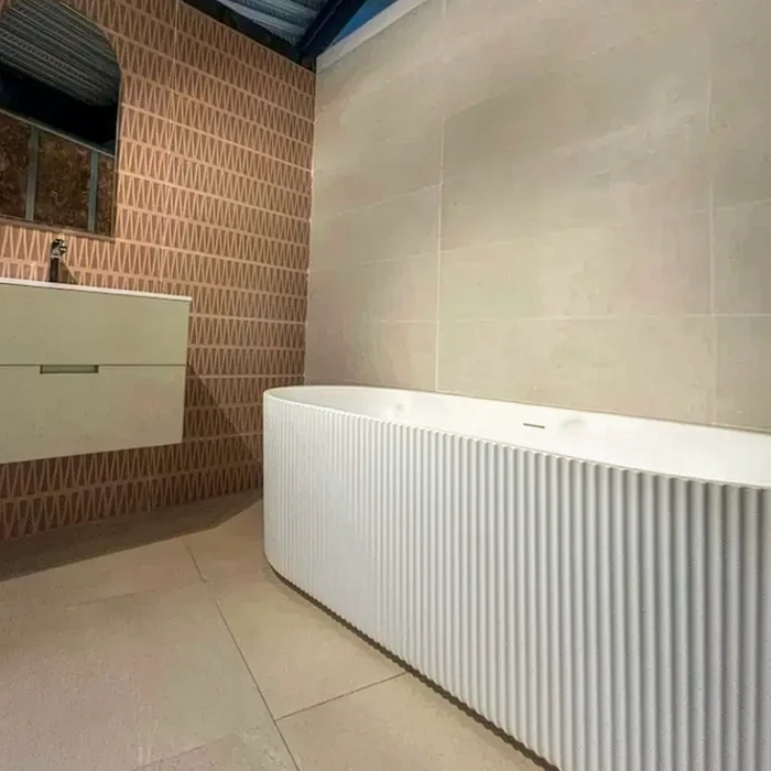 Salle de bains moderne avec baignoire îlot autoportante blanche à façade striée cannelée, style contemporain