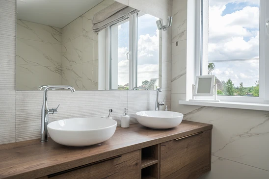 Salle de bain moderne luxueuse avec vasque rectangulaire blanche, robinetterie chrom&eacute;e contemporaine, plan de toilette en marbre blanc vein&eacute;