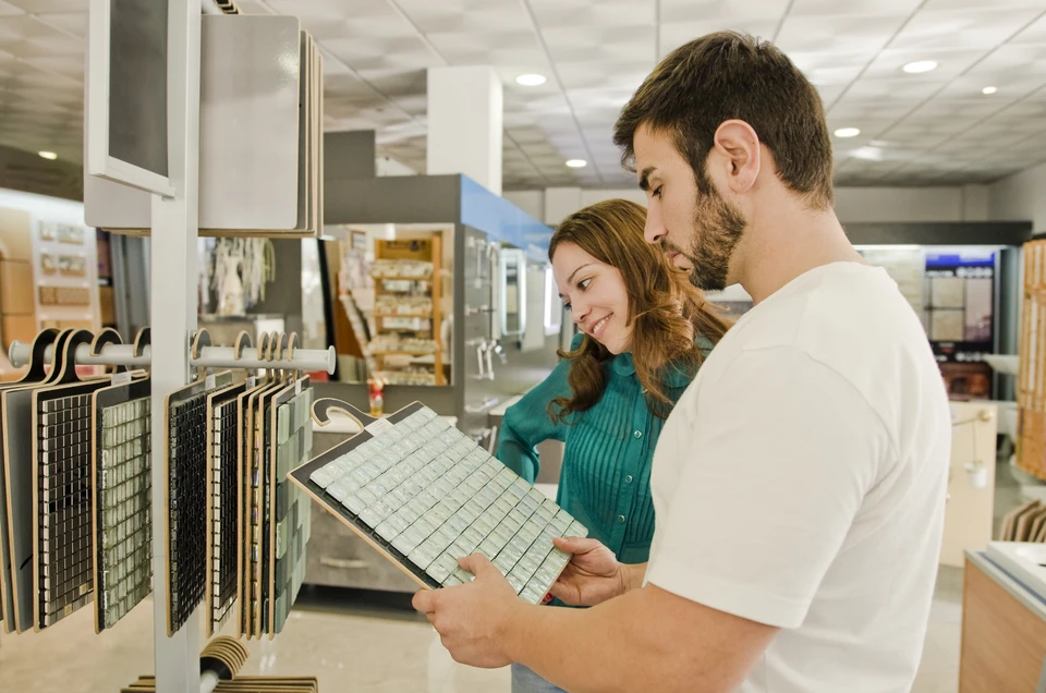 Scène intérieure de showroom avec trois professionnels consultant des échantillons de matériaux