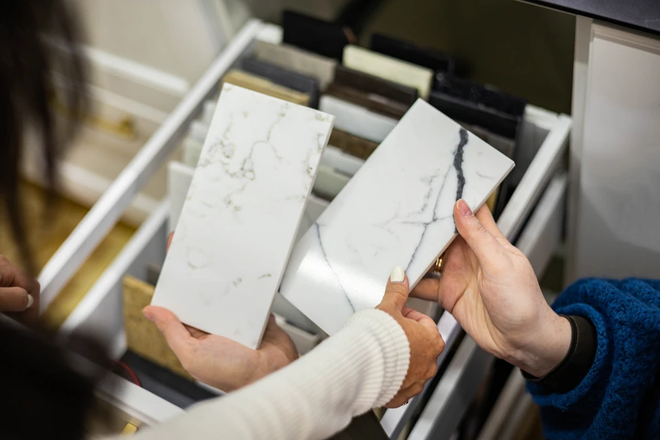 Magasin de revêtements de sol avec couple consultant échantillons de parquet et stratifié auprès d'une vendeuse